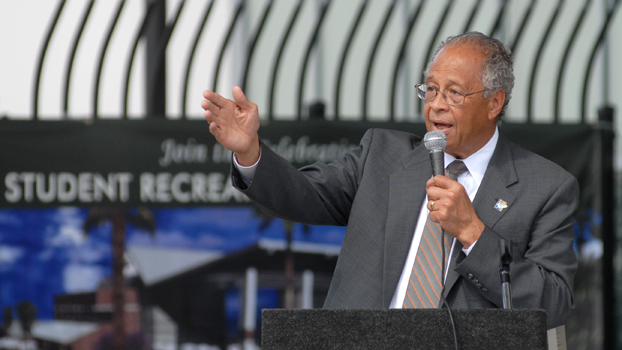 President Milton A. Gordon speaking at a podium.