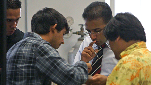 Faculty member surrounded by students.