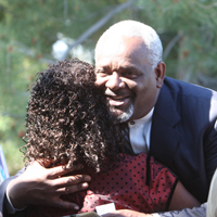 Chuck Moore is hugged during the opening of the Irvine Campus.
