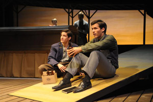 two actors sit on stage during a production of “Owen Meany.”