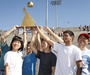 A winning team holds up their trophy.