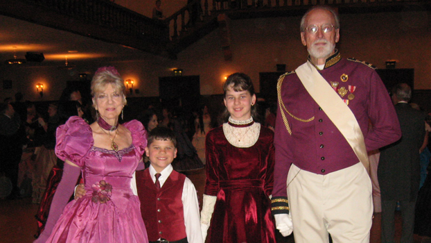 Grandparents and their grandchildren are dressed for the holidays.