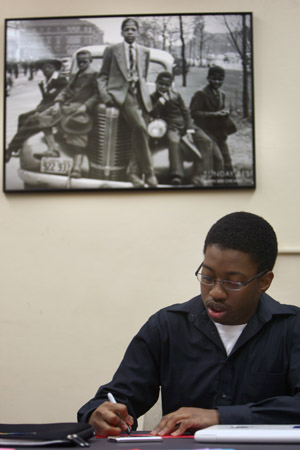 Torell Foree studies under a sepia photograph of black youngsters.