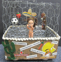 A carboard box topped with chicken wire and decorated with derogatory comments and symbols.