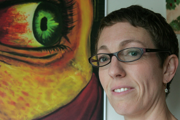 Sharon Chappell stands eyeball to eyeball with one of the pieces of artwork on display in the Pollak Library.