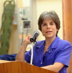 Cindy Smith Greenberg speaks at a podium in the nursing lab.