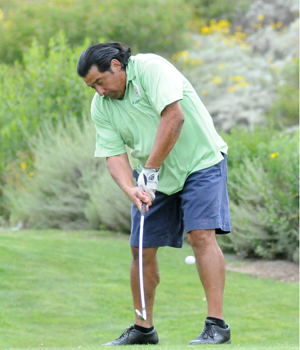 business alumnus tees off during golf tournament.