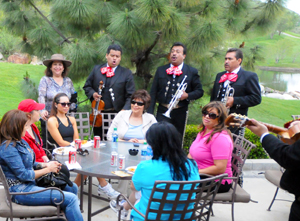 A mariachi band plays to a group of women at a table