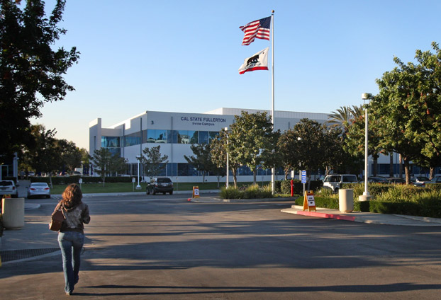 Student walks through the parking lot on her way to the two-story Irvine Campus building.