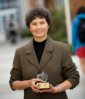 Mabel Kung holding the Barnes crystal apple award.