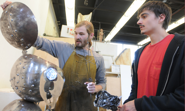 Two students working on robo tboy sculpture. 