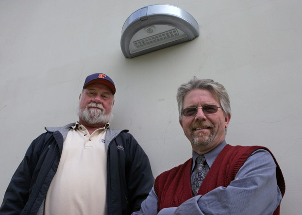 Spence Colman and Willem van der Pol stand under a new lighting fixture being considered for the campus.