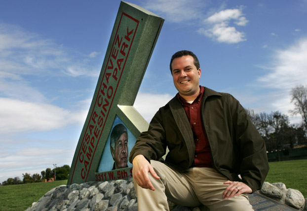 Raymond Rast stands before the sign for  César Chávez Campesino Park in Santa Ana.