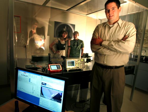 Joshua Smith infront of clean room; two students within the special facility