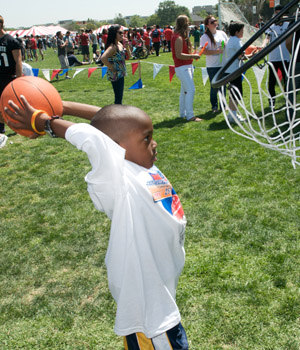 A young basketball player holds the ball behind his head before tossing it into the basket.