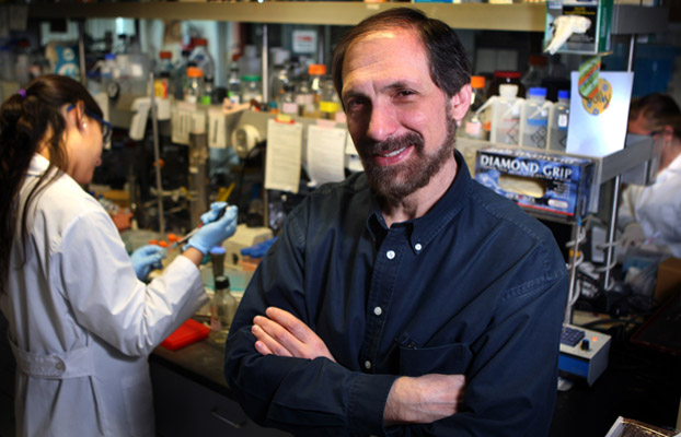 Marcelo Tolmasky in his lab with two students.