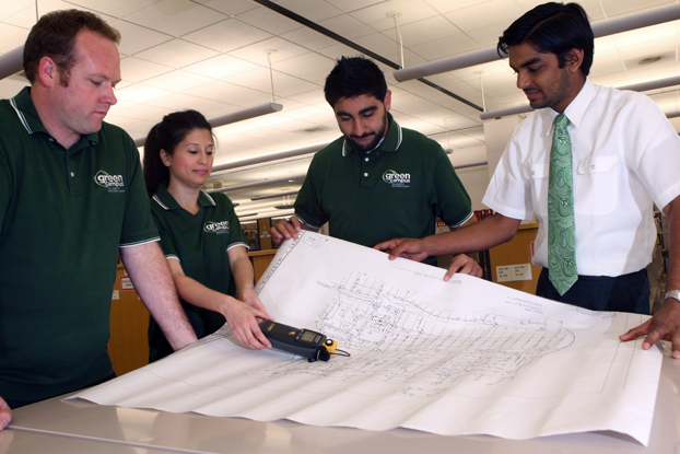 Members of the Green Campus group look over a blueprint of the Pollak Library.