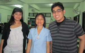 Two hospital staff members stand with CSUF student Russell Lovely Argenal.