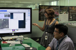 Cinthia Padilla uses a laser pointer to highlight an image on the computer as she talks to an associate.