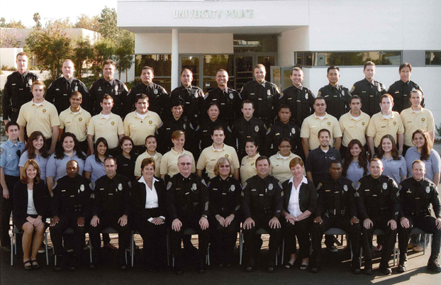 Officers and staff of the CSUF police department posed in front of the police building.