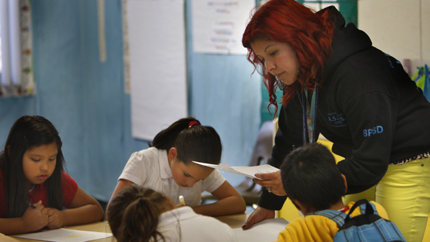 A female college student works with a group of youngsters.
