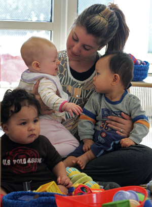 A Children's Centerstaff member holds a couple of her young charges