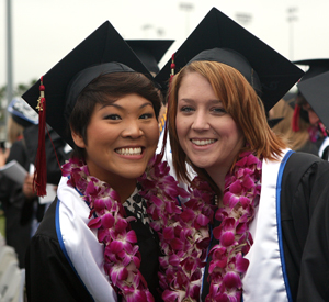 two female graduates hug.
