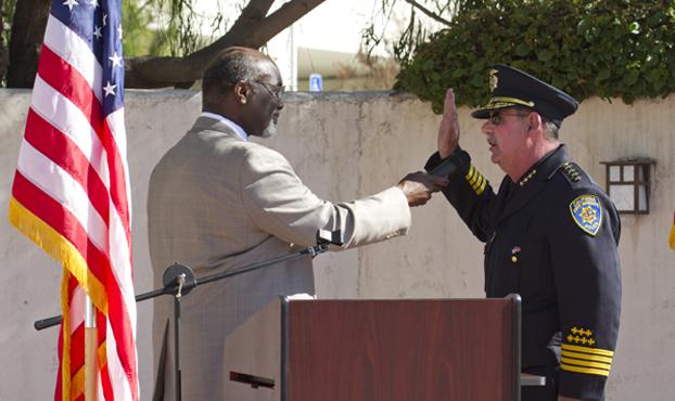 Willie Hagan holds the microphone before Chief DeMaio as DeMaio repeats the oath of office.