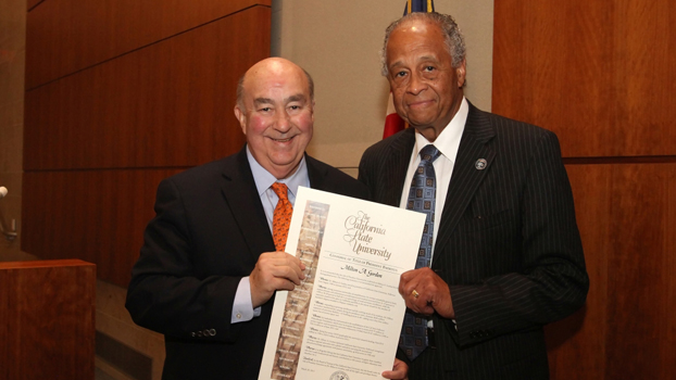 CSU Chancellor Reed stands beside Milton A. Gordon as he presents a resolution naming Gordon emeritus professor.