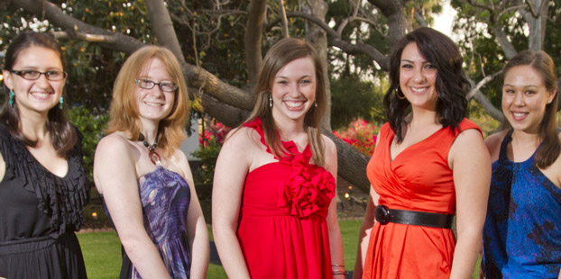 Five young women standing in front of a tree.