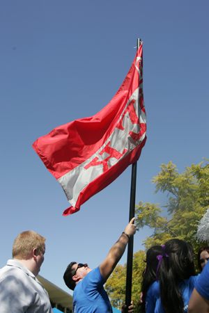 Fraternity members raise a flag.