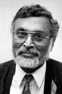 Black and white photo of an older gentleman with curly hair and a salt and pepper beard