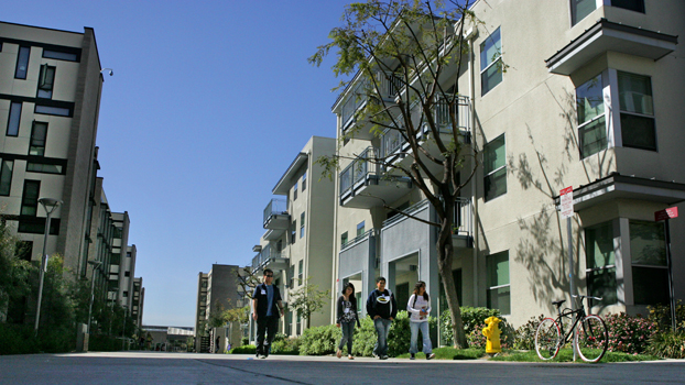 students walk by some of the latest student housing.