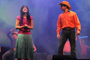 a couple in western garb on stage