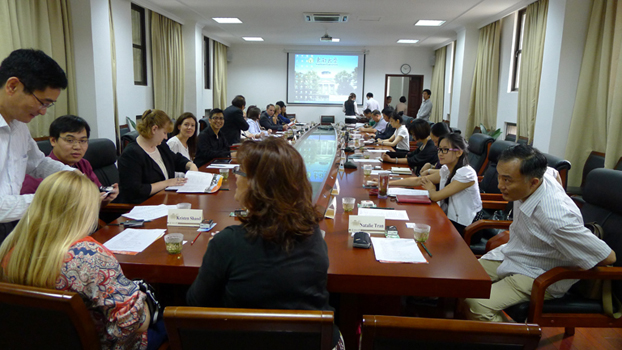 Faculty, staff and administrators sit around a table for a meeting.