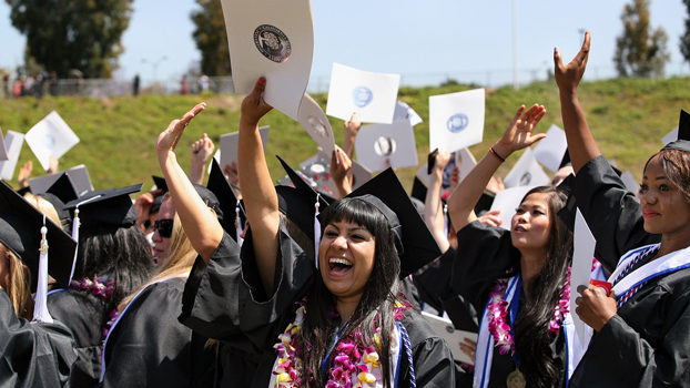 Group of graduates waving at graduation