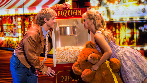 Guy and Gal on either side of a popcorn machine