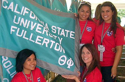 Cal State Fullerton’s Theta Phi Chapter of Zeta Tau Alpha members pose with the flag of their chapter.