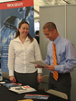Two local businesspeople review marketing materials at their booth.
