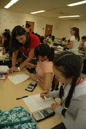 High school girls working out math problems in a classroom.