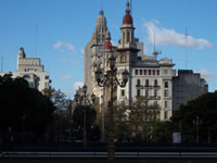 View of juxtaposed old and modern architecture silhouetted against a sunny, clear sky