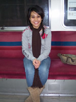 Doreen sitting on a bench in a subway car