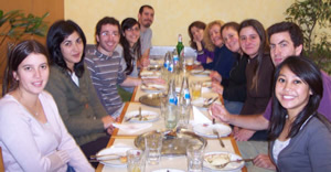 Doreen gathered around a table in a restaurant with many colleagues