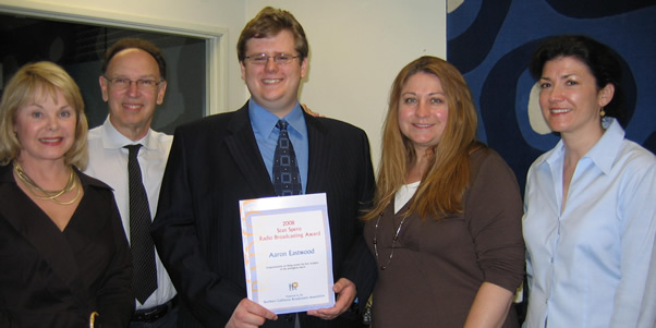 Senior radio-tv-film major Aaron Eastwood is presented an award by faculty members and a representative of the Southern California Broadcasters Association