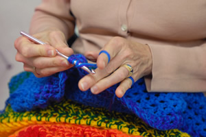 Hands crocheting a blanket