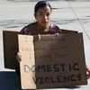 Student seated in quad demonstrating against homelessness