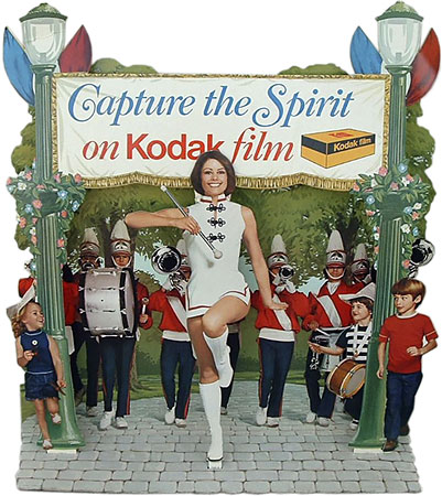 Kodak large ad with marching band and Kodak Girl
