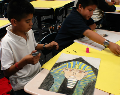 A student from Richmond Elementary School paints an Egyptian pharaoh to reflect studies about ancient civilizations.