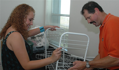 With a little help from dad, Greg, Ashley Doyle puts together a shelf as part of her moving day endeavors. Doyle is a pre-business major from Lompoc.