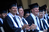 Commencement candidates in caps and gowns seated